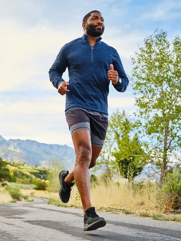 African American man running on asphalt outside
